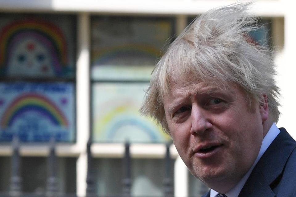 Britain's Prime Minister Boris Johnson stands outside 10 Downing Street to look at posters drawn by children, of rainbows, being used as symbols of hope during the COVID-19 pandemic, and messages of thanks for the workers of Britain's NHS (National Health Service), in central London on May 15, 2020. (Photo by DANIEL LEAL-OLIVAS / AFP) (Photo by DANIEL LEAL-OLIVAS/AFP via Getty Images)