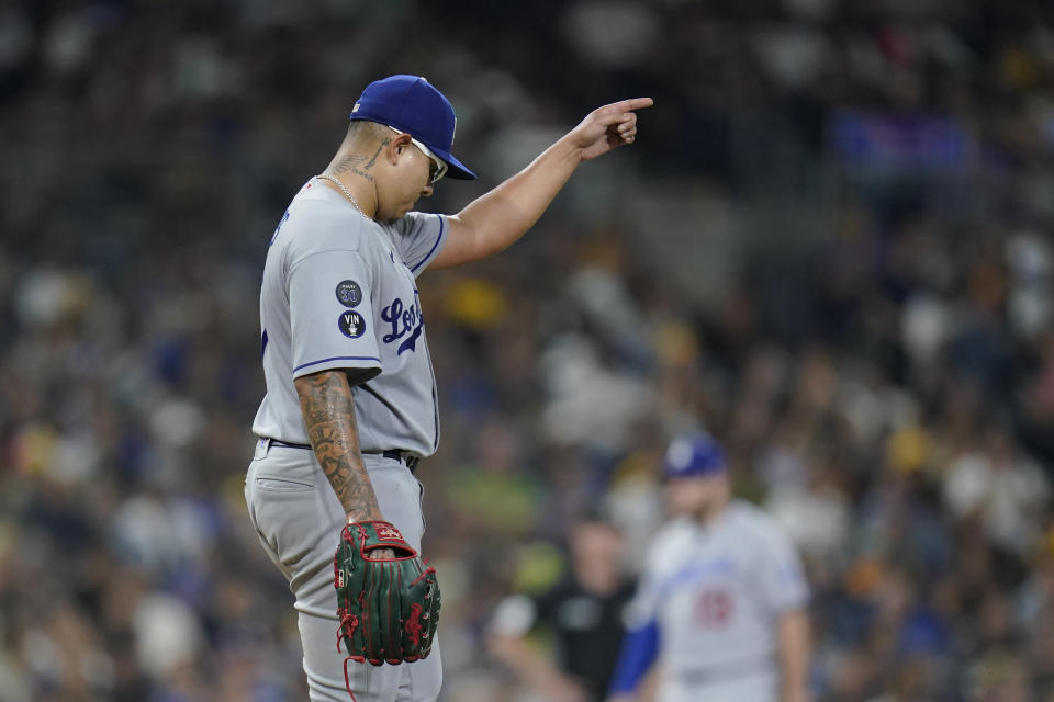 Los Angeles Dodgers starting pitcher Julio Urias points to second base to tell the infield to throw the ball to second base if the chance arises in the next at-bat, after he walked San Diego Padres' Manny Machado during the sixth inning of a baseball game Wednesday, Sept. 28, 2022, in San Diego. (AP Photo/Gregory Bull)