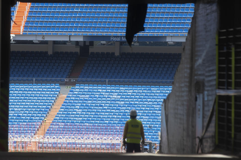 Obreros ingresan al estadio Santiago Bernabéu del Real Madrid, el lunes 25 de mayo de 2020. (AP Foto/Paul White)