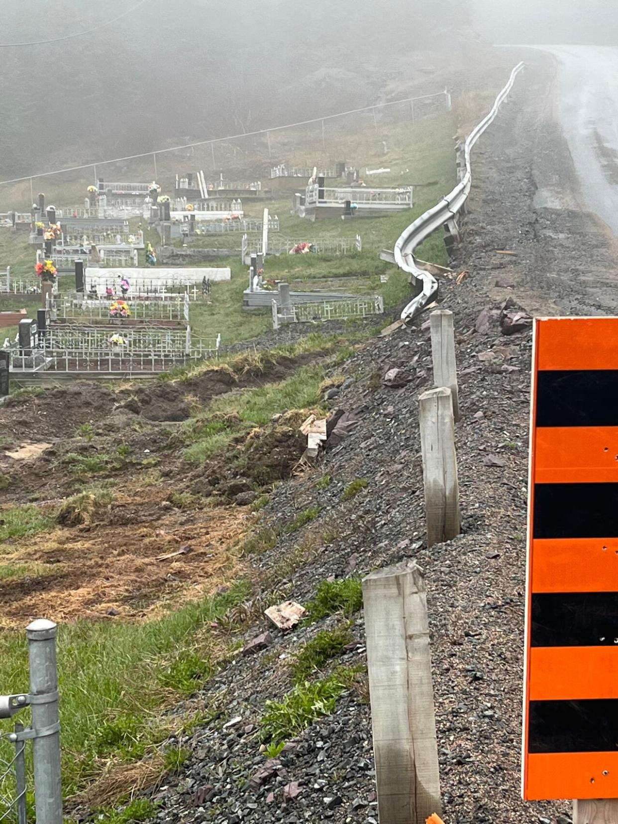 In February a government plough went off the road in Gooseberry Cove, damaging the guard rail, cemetery and its retaining wall.  (Submitted by Ashley Politi - image credit)