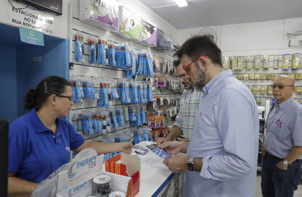 Customers buy masks at a medical supply store, to wear as a precaution against the spread of the new coronavirus COVID-19, in Sao Paulo, Brazil, Wednesday, Feb. 26, 2020. Brazil's government confirmed on Wednesday that a Brazilian man who traveled to Italy this month has Latin America's first confirmed case of the contagious new coronavirus. (AP Photo/Andre Penner)