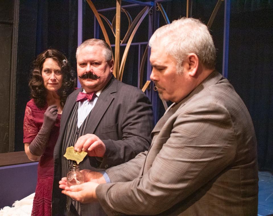 Hercule Poirot (Jeff Tryka, center) and Monsieur Bouc (Keith Sarber) reveal a message in invisible ink in front of Countess Andrenyi (Annette Kaczanowski) in Elkhart Civic Theatre’s production of Agatha Christie’s "Murder on the Orient Express," adapted by Ken Ludwig, that opens Feb. 24 and continues through March 5, 2023, at the Bristol Opera House.