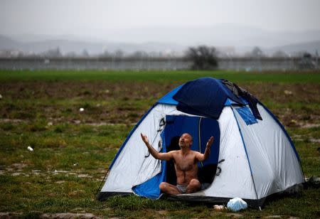 A migrant, who is waiting to cross the Greek-Macedonian border, reacts while being photographed at a makeshift camp near the village of Idomeni, Greece March 9, 2016. REUTERS/Stoyan Nenov