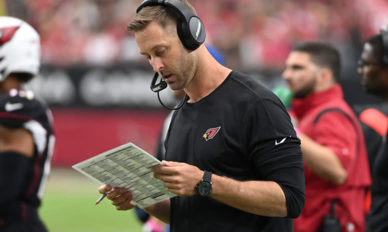 Cardinals head coach Kliff Kingsbury reads his play sheet on the sidelines during a game.