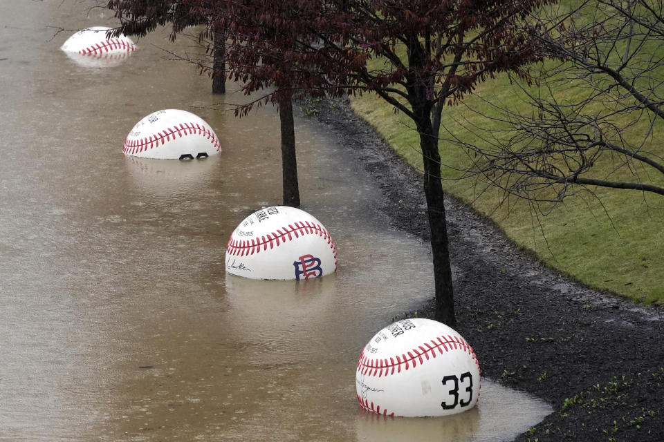 A display of giant baseballs lining the Northshore riverwalk outside PNC Park in Pittsburgh are partially submerged by the overflowing Allegheny River Wednesday, April 3, 2024. (AP Photo/Gene J. Puskar)