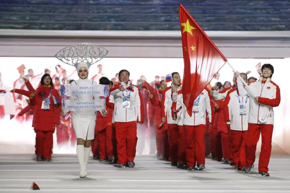 Tong Jian of China carries the national flag as he leads the team during the opening ceremony of the 2014 Winter Olympics in Sochi, Russia, Friday, Feb. 7, 2014. (AP Photo/Mark Humphrey)