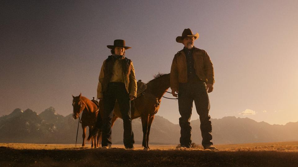 Cecilia Abbott and Royal Abbott looking into the hole with horses standing behind them in Outer Range.