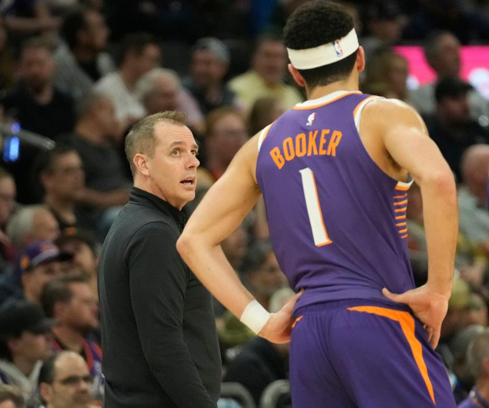 Phoenix Suns head coach Frank Vogel talks with guard Devin Booker (1) during the first quarter against the Sacramento Kings at Footprint Center in Phoenix on Feb. 13, 2024.