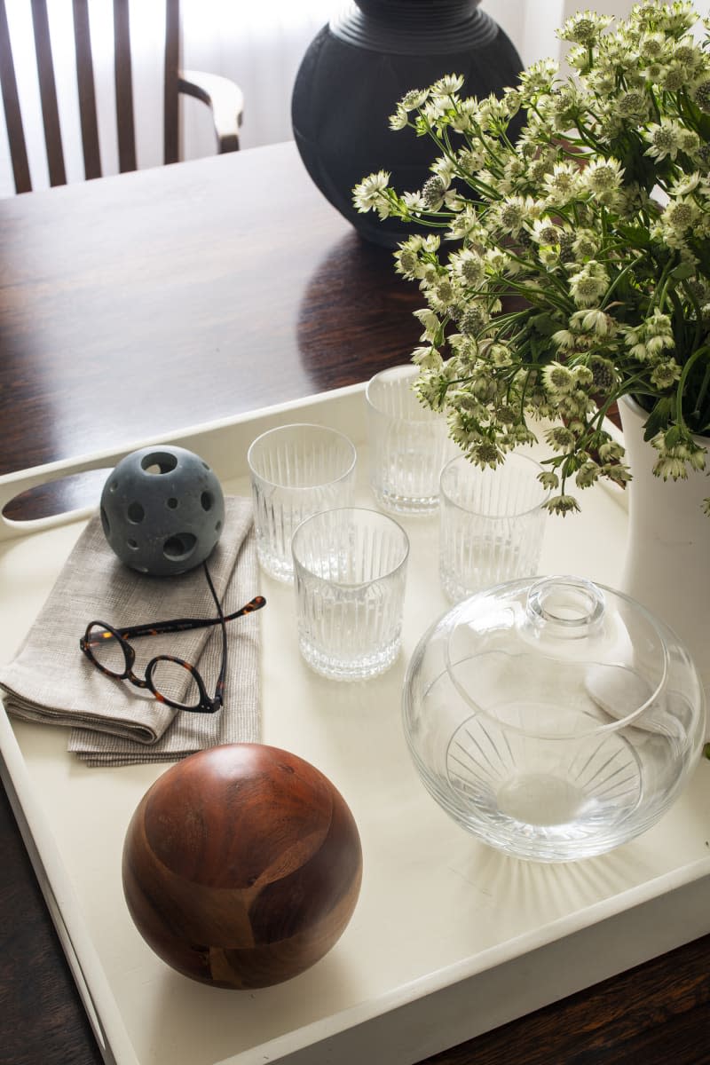 tray on table with glasses, napkins, flowers