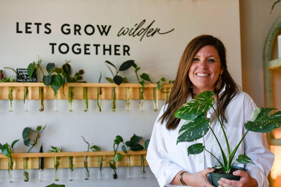 Mary Dunlap, owner of Wilder Plant Shop located inside The Good Market in Travelers Rest, S.C., holds her favorite plant inside the shop on Friday, April 5, 2024.