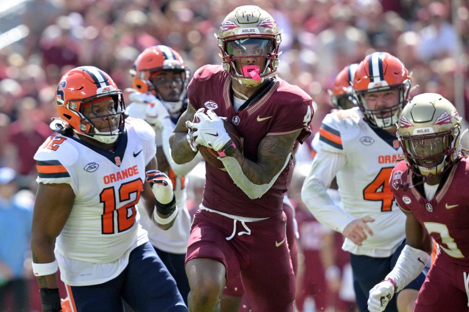 Florida State wide receiver Keon Coleman runs past Syracuse linebacker Anwar Sparrow on a punt return during the first half Saturday, Oct. 14, 2023, in Tallahassee, Fla.