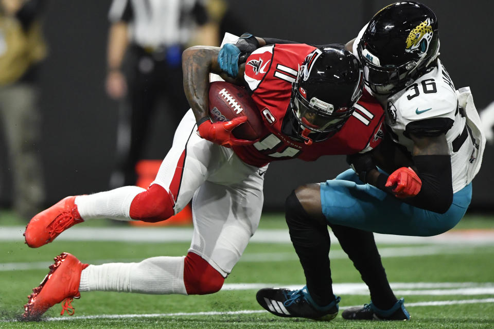 Atlanta Falcons wide receiver Julio Jones (11) is hit by Jacksonville Jaguars safety Ronnie Harrison (36) during the first half of an NFL football game, Sunday, Dec. 22, 2019, in Atlanta. (AP Photo/John Amis)