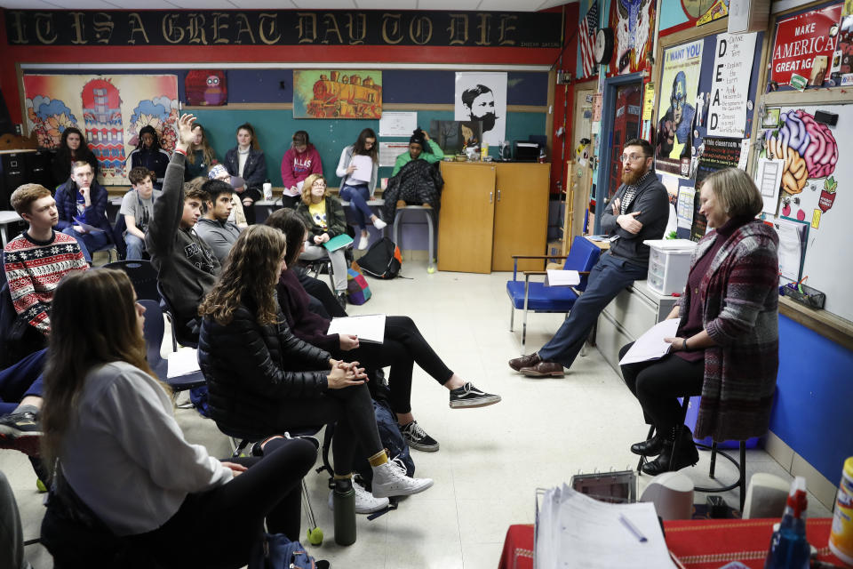 In this Thursday, Jan. 24, 2019, photo students listen as social studies teachers Judi Galasso, right, and Jonathan Duffy, second from right, lead the introductory class of their American Thought and Political Radicalism course at Thomas Worthington High School, in Worthington, Ohio. (AP Photo/John Minchillo)