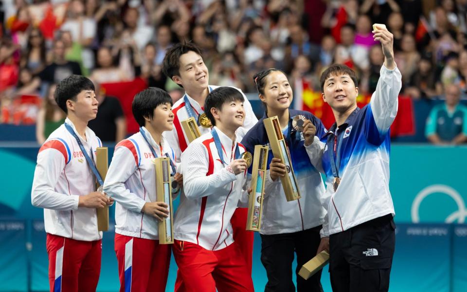 Gold medalists China's Wang Chuqin and Sun Yingsha, silver medalist North Korea's Ri Jong Sik and Kim Kum Yong, bronze medalists South Korea's Lim Jonghoon and Shin Yubin pose for a selfie