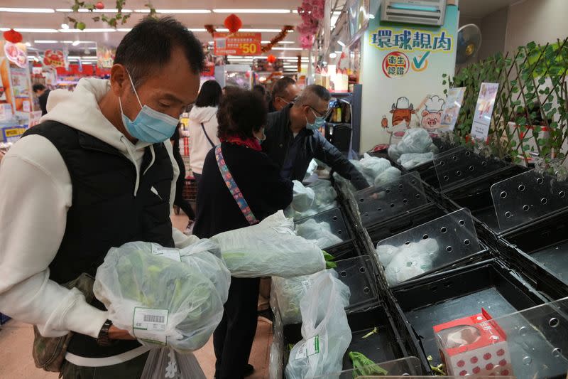 Customers wearing face masks shop at a market, following the outbreak of the coronavirus disease (COVID-19), at Sha Tin district, in Hong Kong