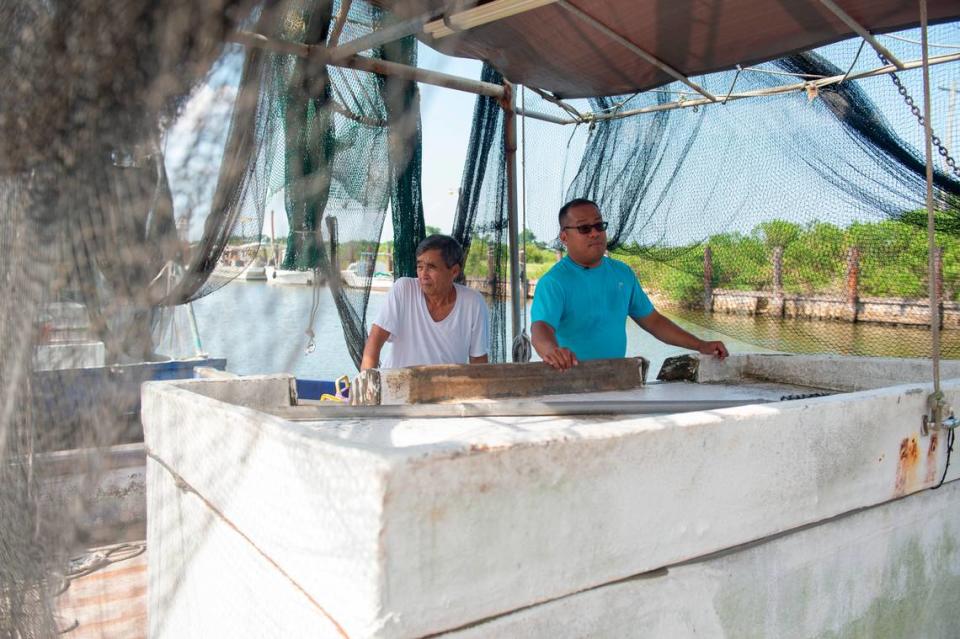 Elvis Ta and his father Sau Truong on Truong’s shrimping boat, Miss Mimi, at Bayou Caddy in Bay St. Louis on Thursday, June 29, 2023. Instead of following his father into the shrimping industry, Ta works for the Department of Agriculture, owns an HVAC company and DJs for weddings on the side.