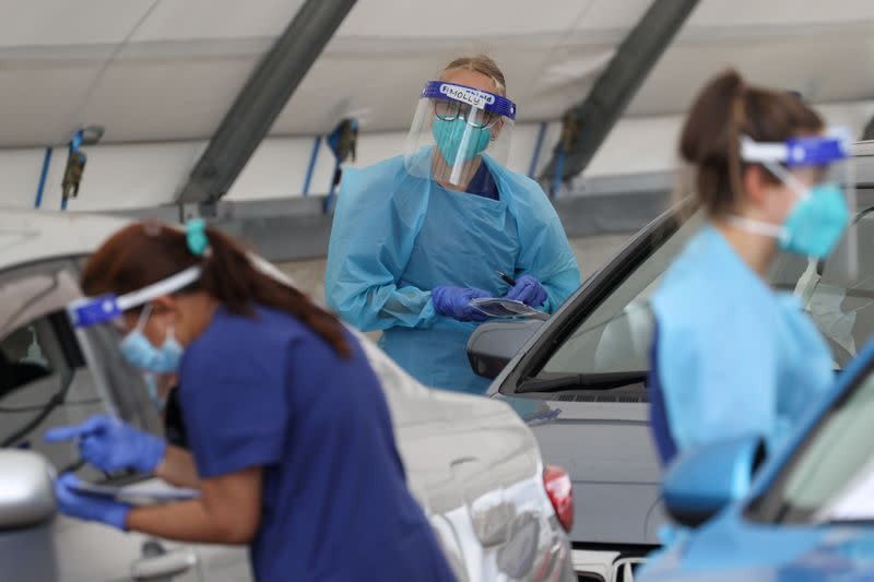 FILE PHOTO: Medical workers administer tests at a drive-through COVID-19 testing centre in Sydney