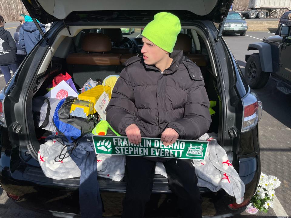 Griswold resident Franklin Delano Stephen Everett sits in the car besides his toy trucks, waiting to wave and greet more trucks on the highway. The lot he's in was unofficially named in his honor Friday, and the official naming is in the works.