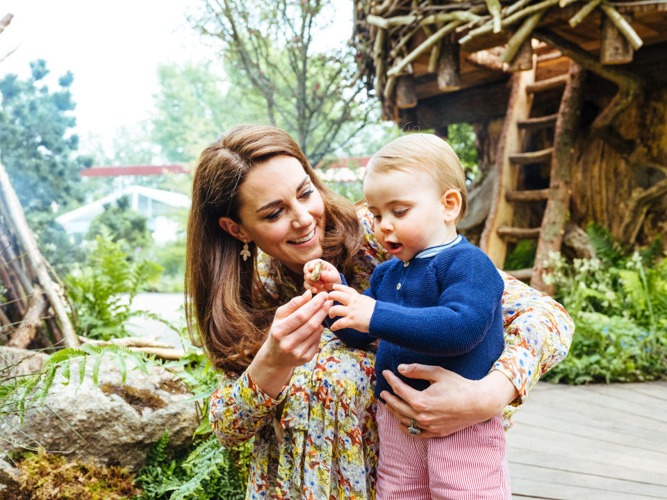 Kate holds Louis as he holds a pebble from the garden [Photo: Matt Porteous]