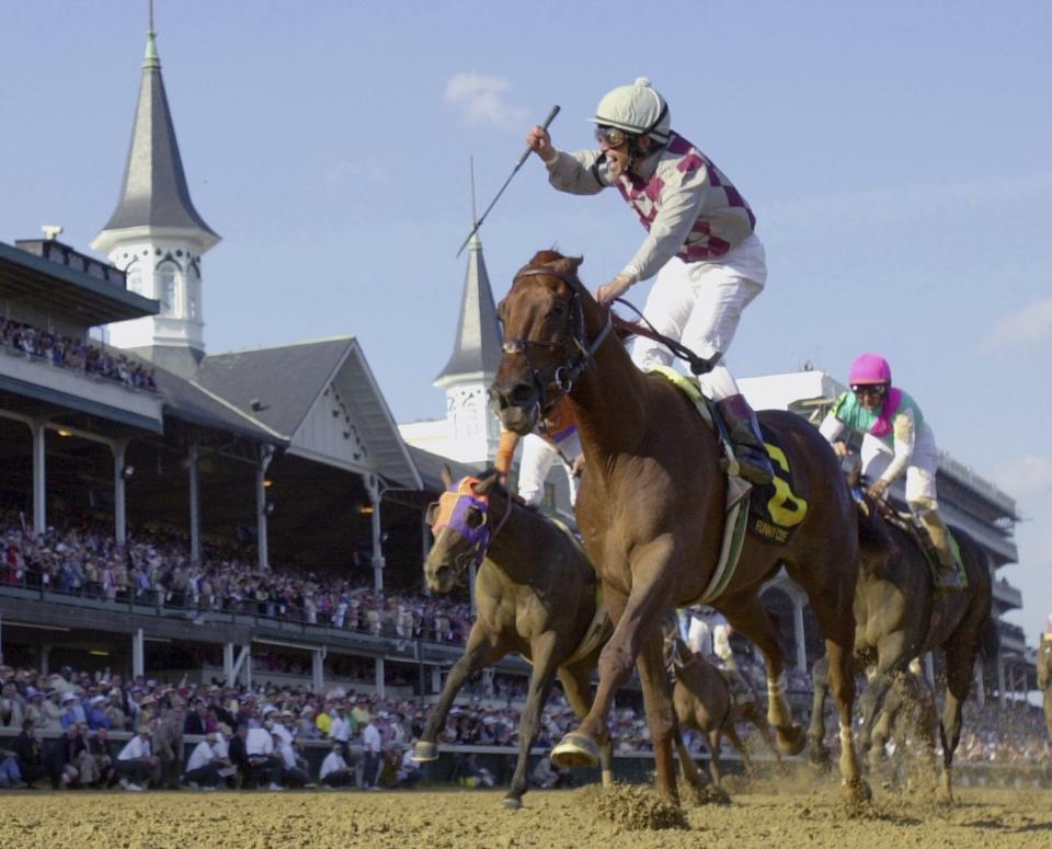 FILE - Jockey Jose Santos celebrates aboard Funny Cide after crossing the finish line to win the 129th running of the Kentucky Derby at Churchill Downs on May 3, 2003, in Louisville, Ky. Cide, the “Gutsy Gelding” who became a fan favorite after winning the Kentucky Derby and Preakness in 2003, has died of complications resulting from colic on Sunday, July 16, 2023. He was 23. (AP Photo/Al Behrman, File)