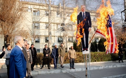 Iranian hardliners burn a cutout poster depicting British ambassador to Iran Robert Macaire - Credit: REX