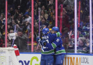 Vancouver Canucks' Dakota Joshua, right, and Elias Lindholm celebrate Joshua's goal against the Calgary Flames during the second period of an NHL hockey game Tuesday, April 16, 2024, in Vancouver, British Columbia. (Darryl Dyck/The Canadian Press via AP)