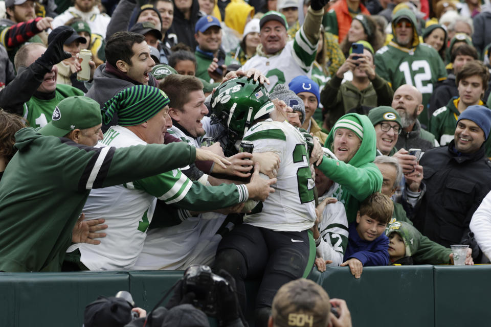 New York Jets running back Breece Hall jumps into the Jets' fans area to celebrate his 34-yard rushing touchdown during the second half of an NFL football game against the Green Bay Packers, Sunday, Oct. 16, 2022, in Green Bay, Wis. (AP Photo/Matt Ludtke)