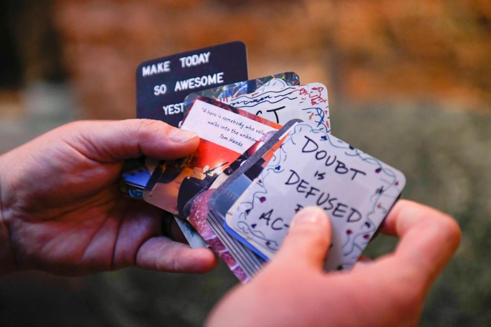 Bex Miller shows off their business cards after performing an improv comedy show at Alchemy Comedy in downtown Greenville, S.C., on Friday, June 30 , 2023. Each one of the cards is made with a different combination of art and their favorite quotes.