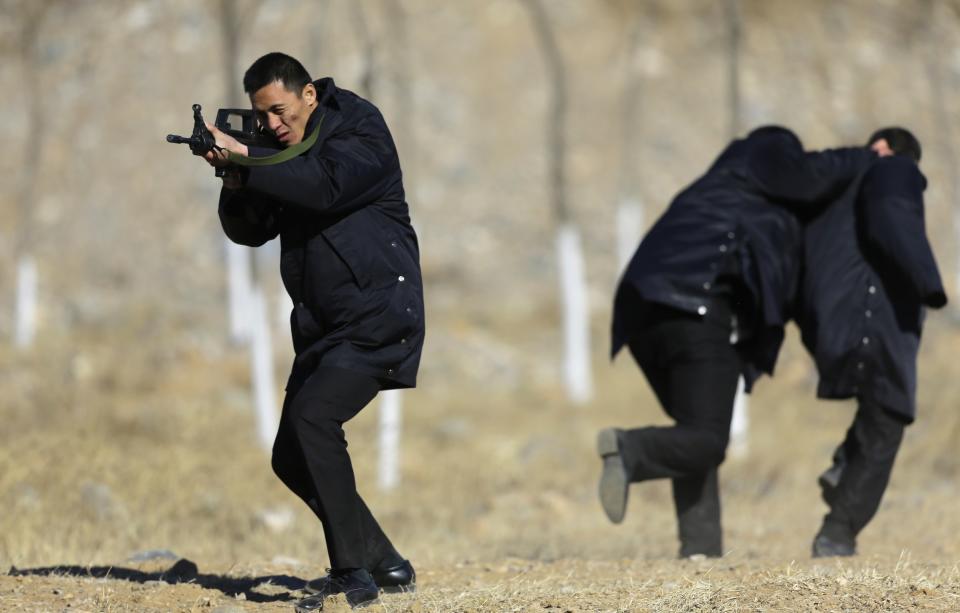 Students practice protecting employers at a shooting training field managed by the military during Tianjiao Special Guard/Security Consultant training on the outskirts of Beijing