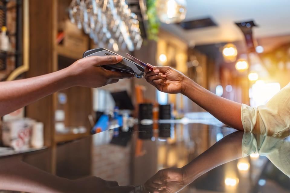 A person makes a credit card payment at a bar.