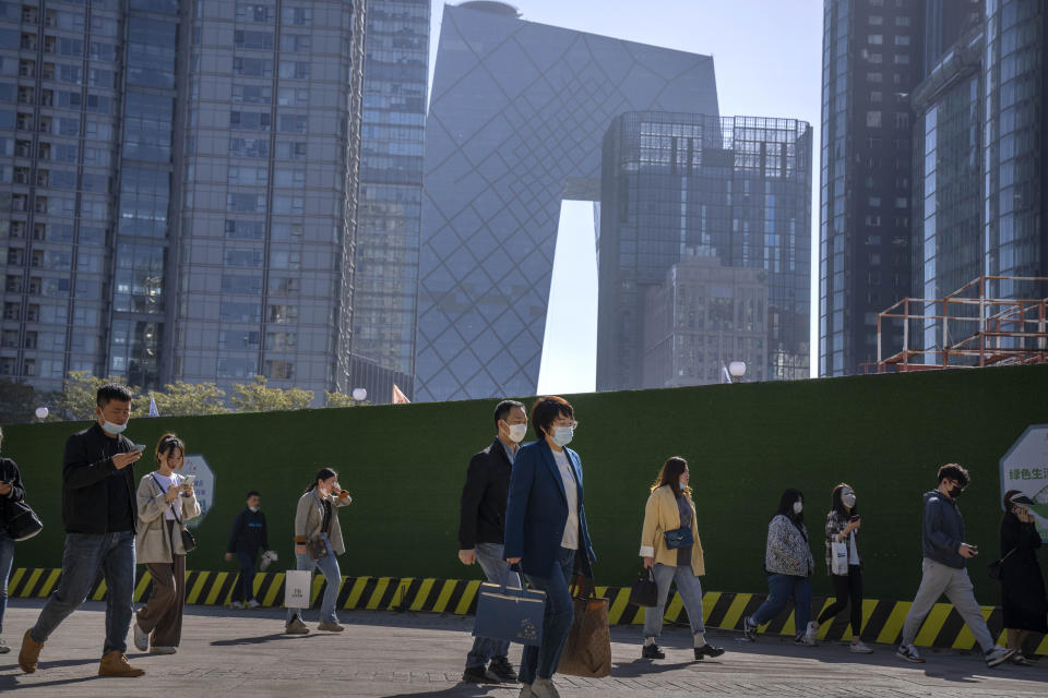 Commuters walk along a path in the central business district during the morning rush hour in Beijing, Tuesday, April 18, 2023. China’s economy grew 4.5% in the first quarter of the year, boosted by increased consumption and retail sales, after authorities abruptly abandoned the stringent "zero-COVID" strategy. (AP Photo/Mark Schiefelbein)