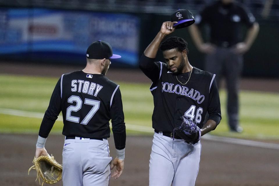 Colorado Rockies starting pitcher Antonio Santos (46) gets a visit from shortstop Trevor Story (27) during the first inning in the second game of a baseball doubleheader against the Arizona Diamondbacks on Friday, Sept. 25, 2020, in Phoenix. (AP Photo/Ross D. Franklin)