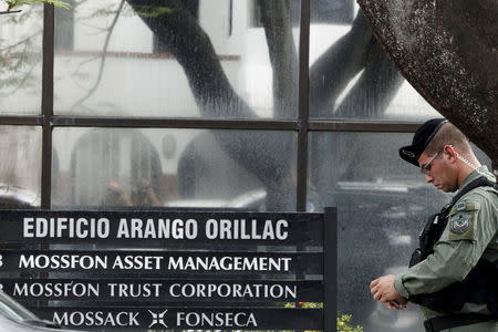 Police officers stand guard next to a company list showing the Mossack Fonseca law firm outside their office in Panama City April 12, 2016. REUTERS/Carlos Jasso