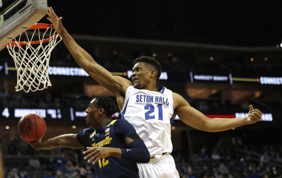 Marquette forward Olivier-Maxence Prosper (12) drives to the basket against Seton Hall center Ike Obiagu (21) during the first half of an NCAA college basketball game in Newark, N.J., Wednesday, Jan. 26, 2022. (AP Photo/Noah K. Murray)