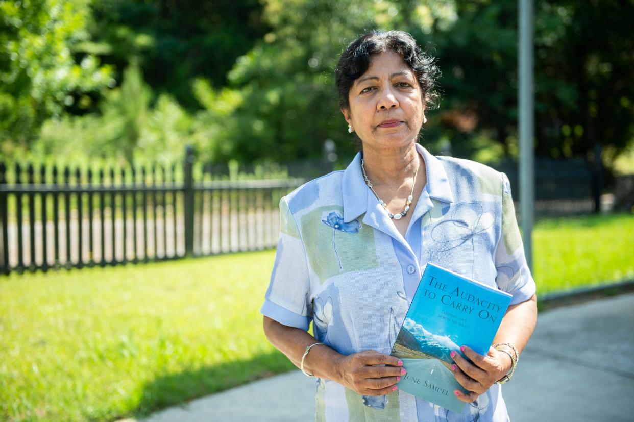 June Samuel poses with a copy of her book “The Audacity to Carry On” at her home in Tuskegee, Ala., on Friday, June 17, 2022.