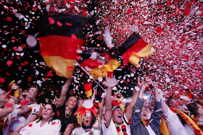 TOPSHOTS Supporters of the German national football team cheer with German flags at the end of the public screening of Germany's opening match in the UEFA Euro 2012 against Portugal at the "Fanmeile" (Fan Mile) in Berlin on June 9, 2012. Germany won 1:0 against Portugal. AFP PHOTO / MICHELE TANTUSSIMICHELE TANTUSSI/AFP/GettyImages