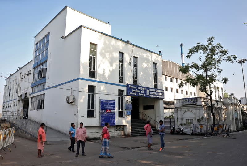 People stand outside Nimtala Crematorium, where a coronavirus positive patient Samir Kumar Mitra was cremated on March 23, in Kolkata