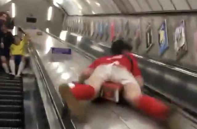 Drunk man slides down centre of escalator on London Underground