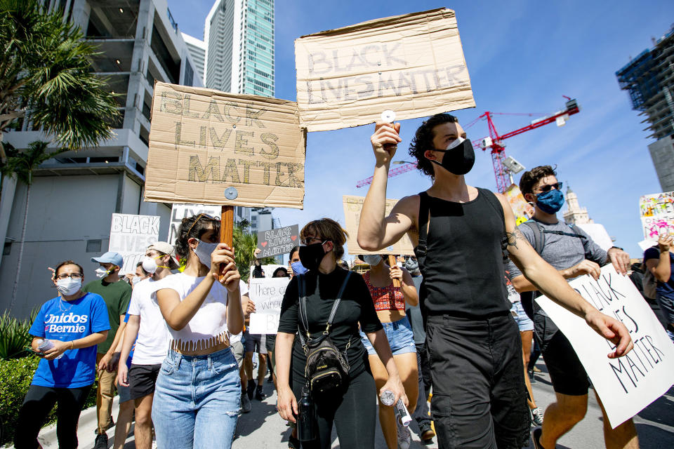 <p>Camila Cabello and Shawn Mendes hold Black Lives Matter signs as they march on Sunday in downtown Miami during day two of the Justice for George Floyd protests.</p>
