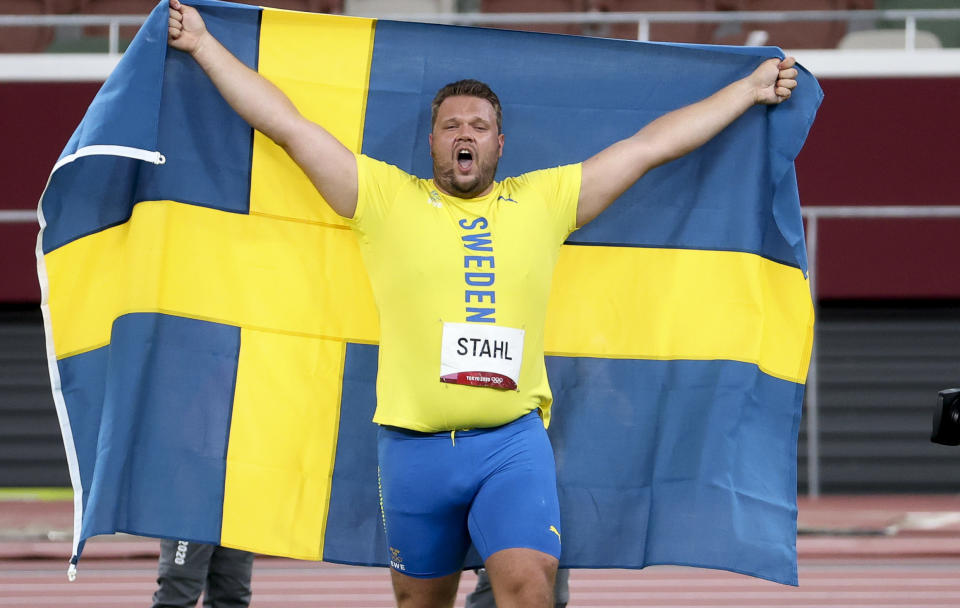 Daniel Stahl of Sweden celebrates with country's flag draped over him