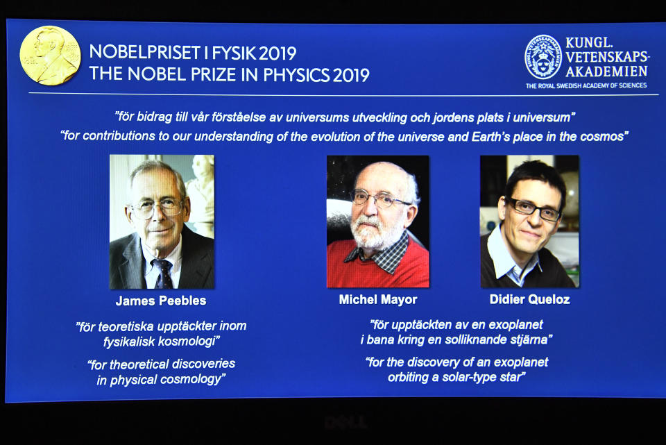 A screen displays the portraits of the laureates of the 2019 Nobel Prize in Physics, with left to right, James Peebles, Michel Mayor and Didier Queloz, during a news conference at the Royal Swedish Academy of Sciences in Stockholm, Sweden, on Tuesday Oct. 8, 2019. (Claudio Bresciani / TT via AP)