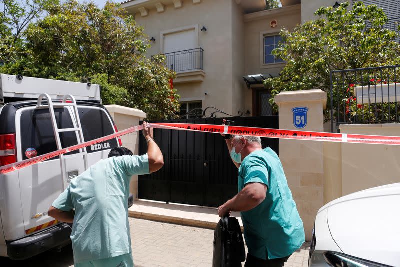 Doctor Chen Kugel, head of Israel National Center of Forensic Medicine and his colleague, pass through a police cordon as they enter China's ambassador to Israel, Du Wei's house in Herzliya, near Tel Aviv, Israel