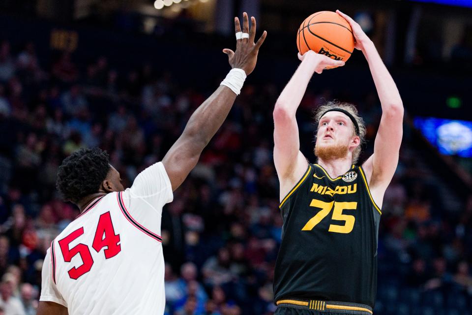 Mar. 13, 2024; Nashville, Tennessee, United States; Missouri center Connor Vanover (75) shoots over Georgia center Russel Tchewa (54) during a MenÕs SEC basketball tournament game at Bridgestone Arena.