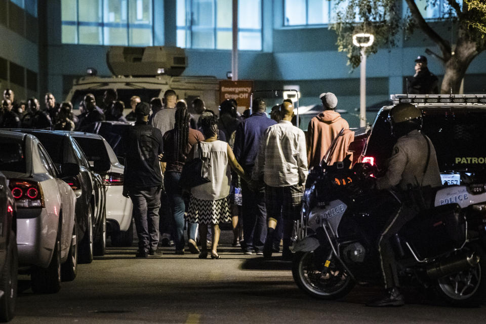 Family members and law enforcement agencies gather outside the emergency room entrance to the Riverside University Health System Medical Center in Moreno Valley after an officer was killed in a shootout following a traffic stop in Riverside on Monday, Aug 12, 2019. (Watchara Phomicinda/The Orange County Register via AP)