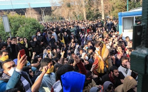 Iranian students protest at the University of Tehran during a demonstration driven by anger over economic problems, in the capital Tehran - Credit: AFP