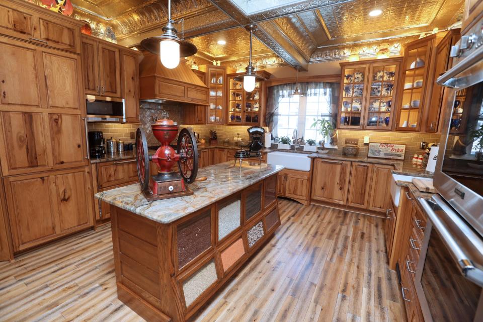 A tin ceiling helps create a general store theme for Bill Hansen and Bob Groth in their 1884 Italianate-style home in Racine.  The island is a cabinet dating to the 1890s or 1900s, and the homeowners added the granite countertop.