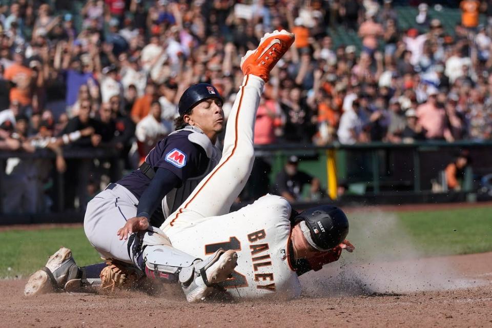 San Francisco Giants' Patrick Bailey, bottom, scores the winning run against Cleveland Guardians catcher Bo Naylor during the 10th inning of a baseball game in San Francisco, Wednesday, Sept. 13, 2023. The Giants won 6-5. (AP Photo/Jeff Chiu)