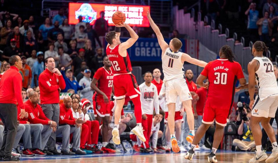 N.C. State’s Michael O’Connell (12) launches a three-point shot over Virginia’s Isaac McKneely (11) at the buzzer in regulation to tie Virginia 58-58 and force overtime during the semi-finals of the ACC Men’s Basketball Tournament at Capitol One Arena on Friday, March 15, 2024 in Washington, D.C.