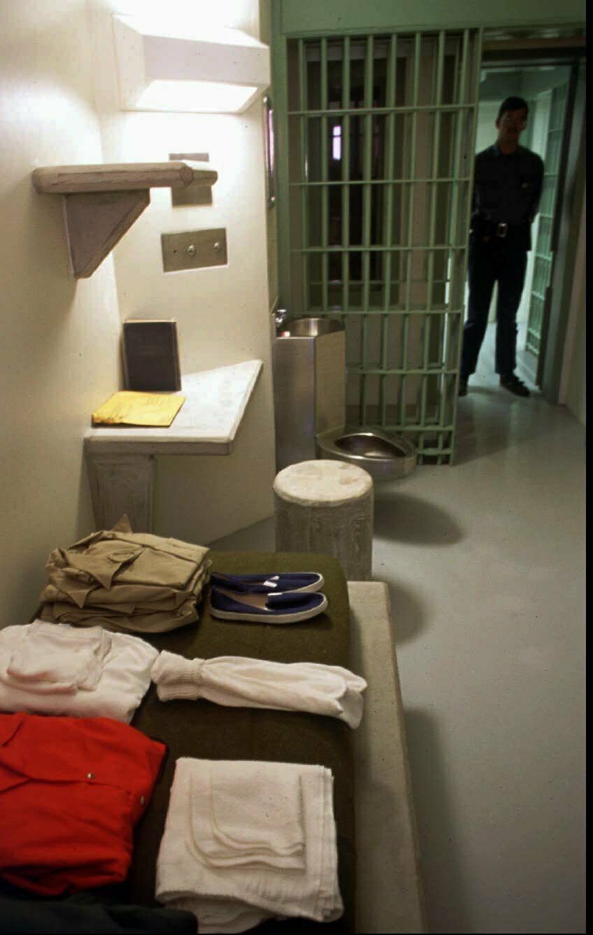 In this 1994 file photo, federal corrections officer William Brown stands in the doorway of a typical cell in a general population unit at the US Penitentiary, Administrative Maximum Security facility in Florence, Colo. Experts say the drug lord Joaquin "El Chapo" Guzman, who will be sentenced on June 25, 2019, for smuggling enormous amounts of narcotics into the U.S. and having a hand in dozens of murders, seems the ideal candidate for the federal government's "Supermax" prison in Florence, Colo., also known as ADX for "administrative maximum," a facility so secure, so remote and so austere that it has been called the "Alcatraz of the Rockies." (Mark Reis/The Gazette via AP, File)