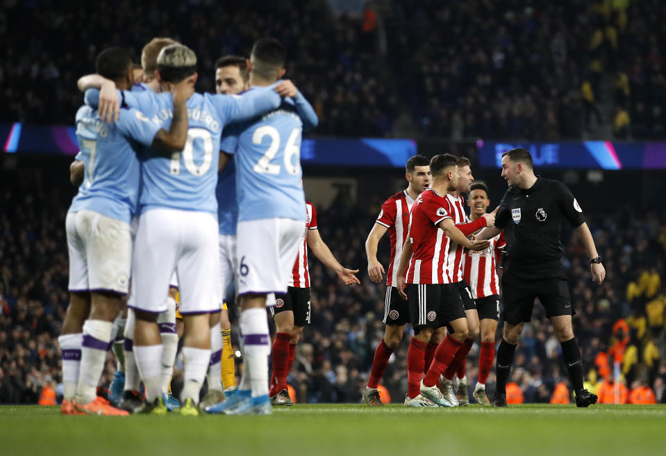 Manchester City's Sergio Aguero (left) celebrates scoring his side's first goal of the game with team-mates as Sheffield United players argue with referee Chris Kavanagh (right) during the Premier League match at The Etihad Stadium, Manchester. (Photo by Martin Rickett/PA Images via Getty Images)